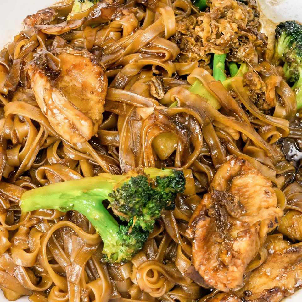 Close-up of Thai Village's Pad See Ew with wide noodles, chicken, and broccoli.