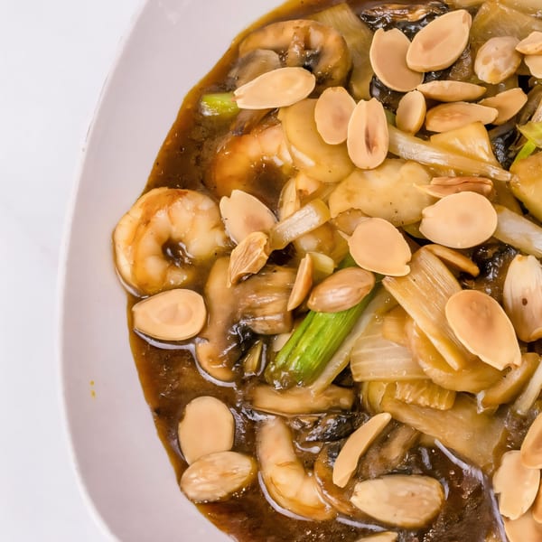 Close-up of Thai Village's shrimp, mushrooms, and vegetables in a rich brown sauce, topped with almonds.