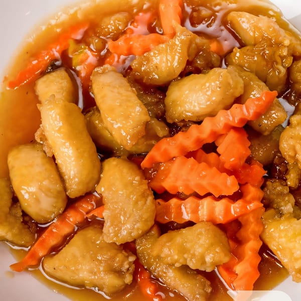 Sweet and sour chicken with crinkle-cut carrots in a rich, golden sauce.
