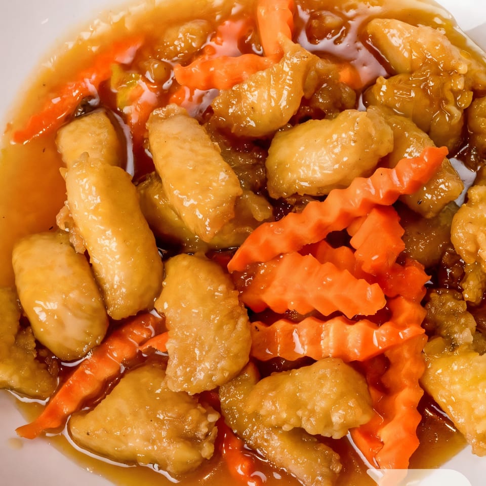 Sweet and sour chicken with crinkle-cut carrots in a rich, golden sauce.